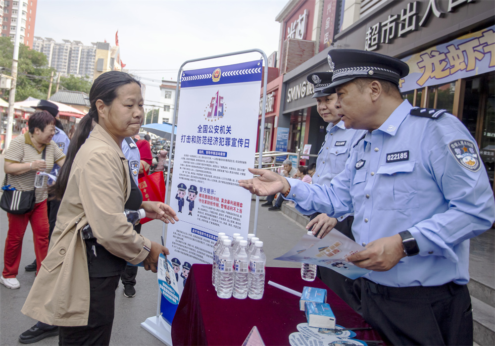 民警向群众发放反诈宣传资料、讲解典型案例。聂长青摄