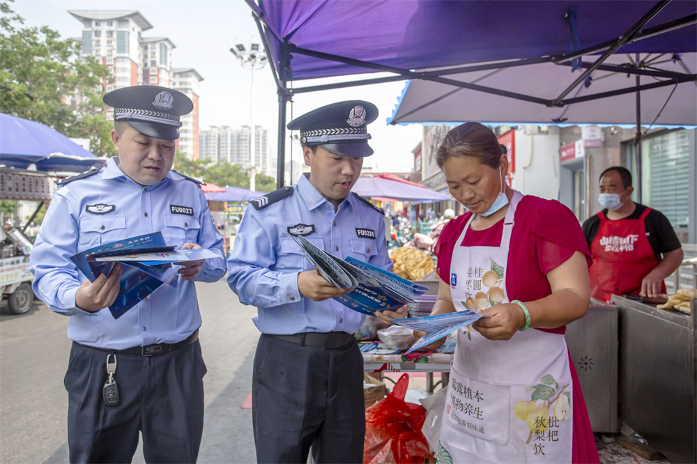 民警向群众发放反诈宣传资料、讲解典型案例。聂长青摄