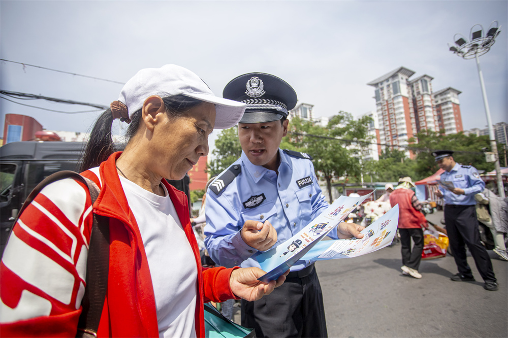 民警向群众发放反诈宣传资料、讲解典型案例。聂长青摄