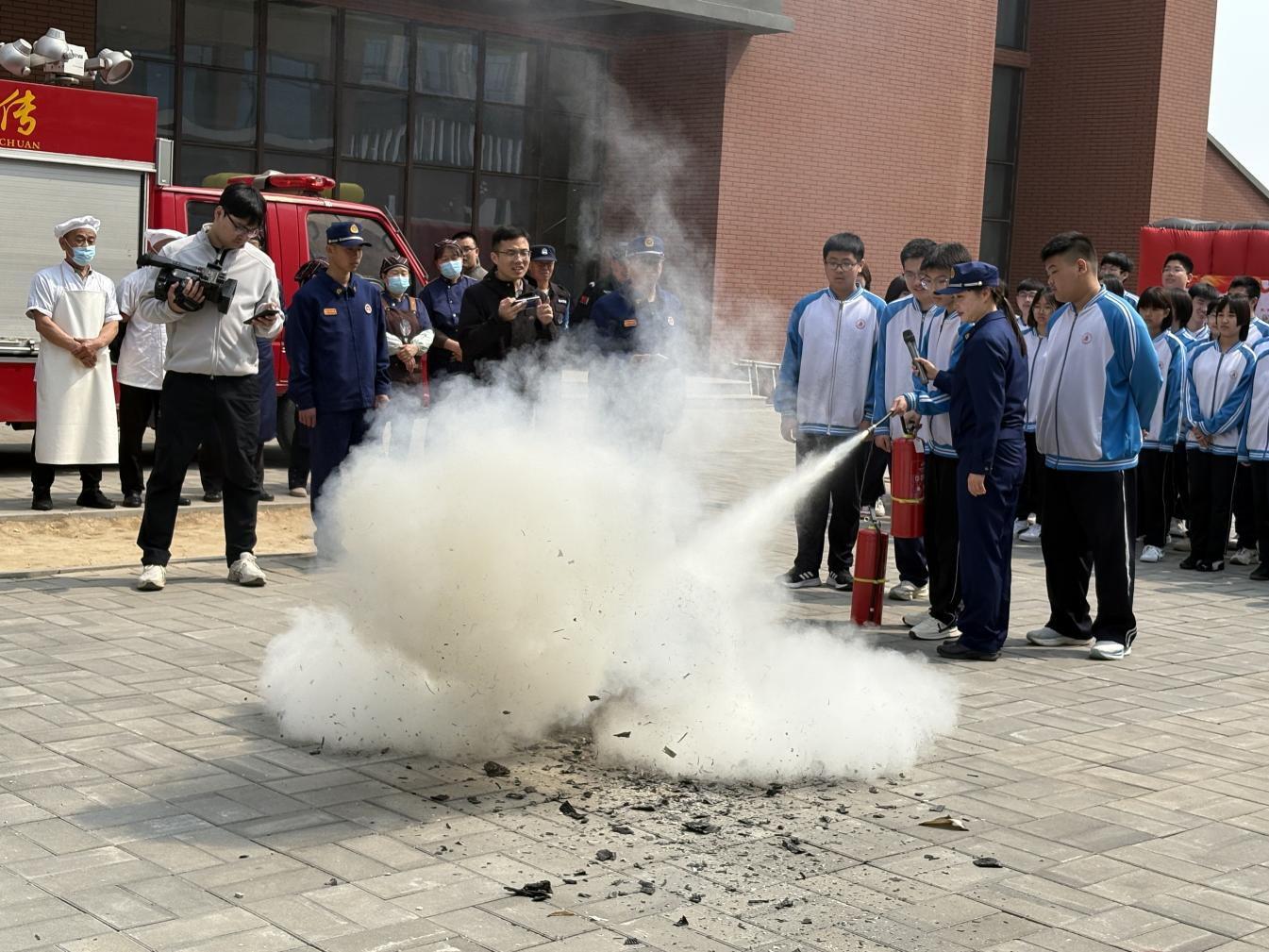 在操場，教官教導學生滅火器正確用法。孟智琳攝