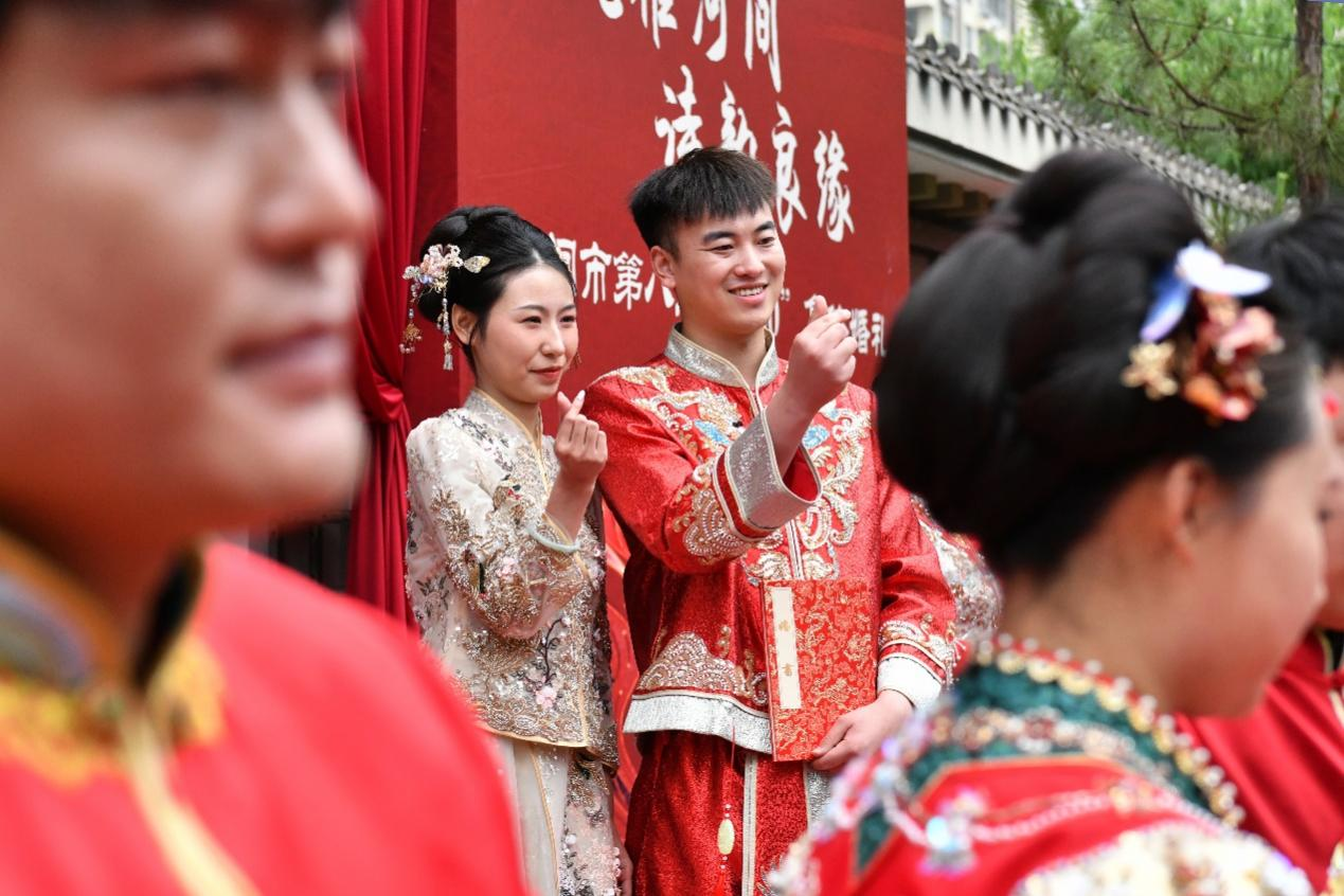 5月20日，一對新人在第八屆“5·20”集體婚禮現場比心。苑立偉攝