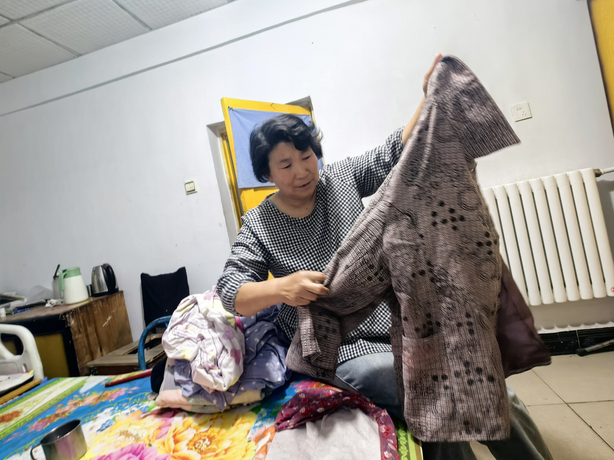 史英桃将洗好的衣服叠放整齐。王晓娜摄