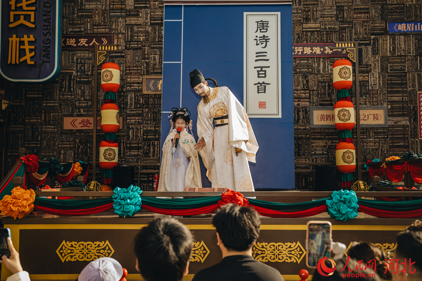 5月18日,河北唐山河头老街NPC“李白”正在景区内与围拢的小游客吟诗作对。人民网记者 商帆摄