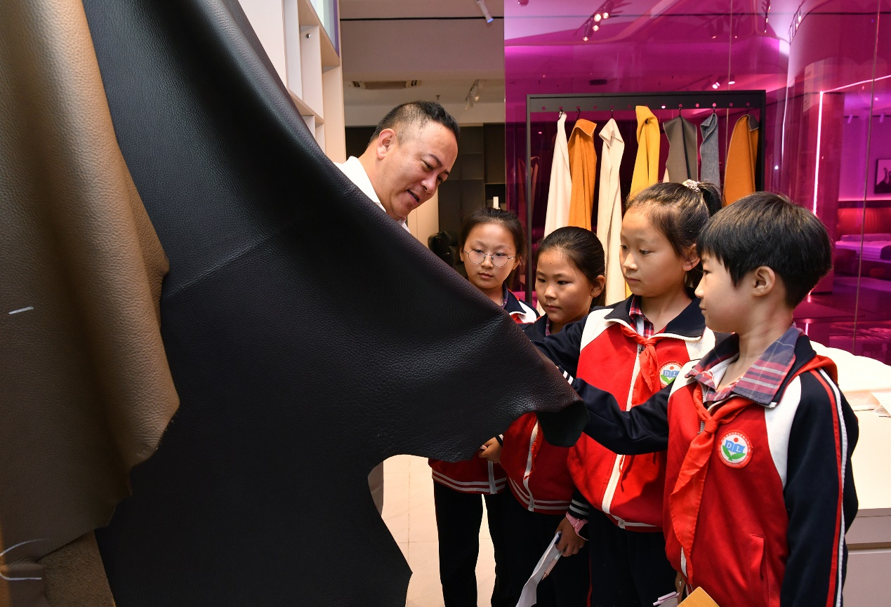在河北力軍力家具制造有限公司展廳，工作人員為學生講解沙發部件及構成。苑立偉攝