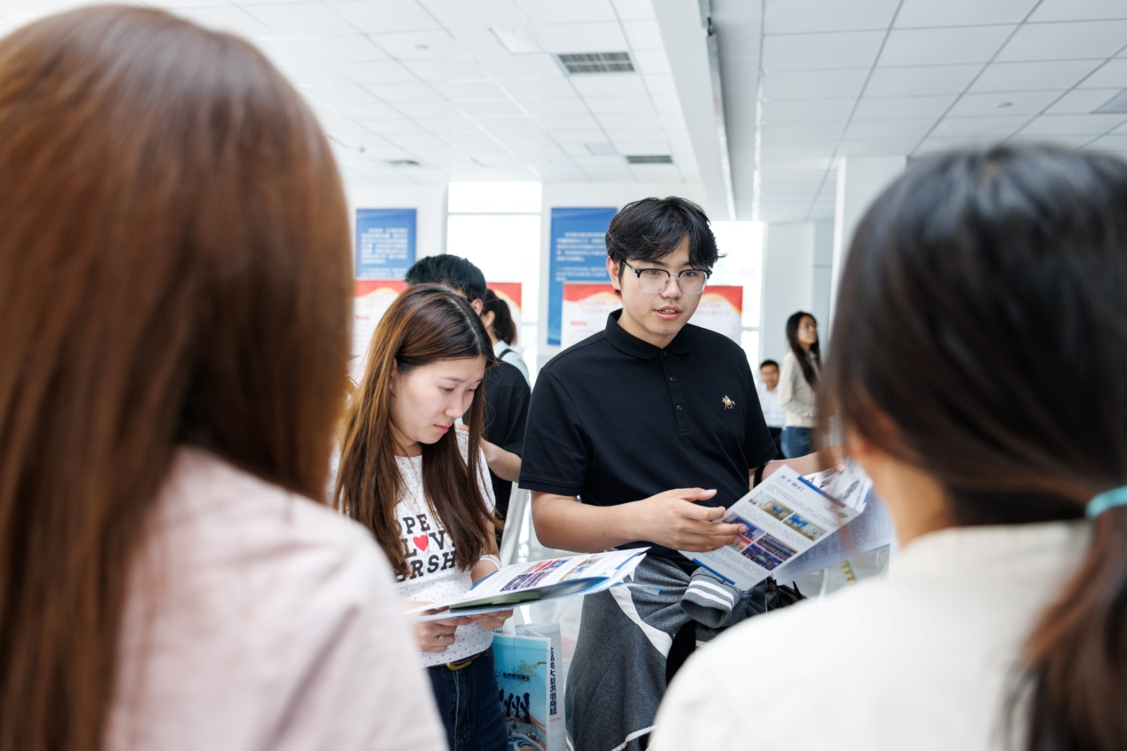 学生正在招聘会现场询问职位情况。孔超摄