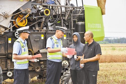 6月3日，在平乡县人民街社区麦田，平乡公安交管大队民警向农机手解读相关政策。 为保障“三夏”生产道路安全、有序、畅通，我省公安交管部门制定政策，快速处置农忙期间道路突发状况，全力护航“三夏”生产。本报记者 赵永辉摄