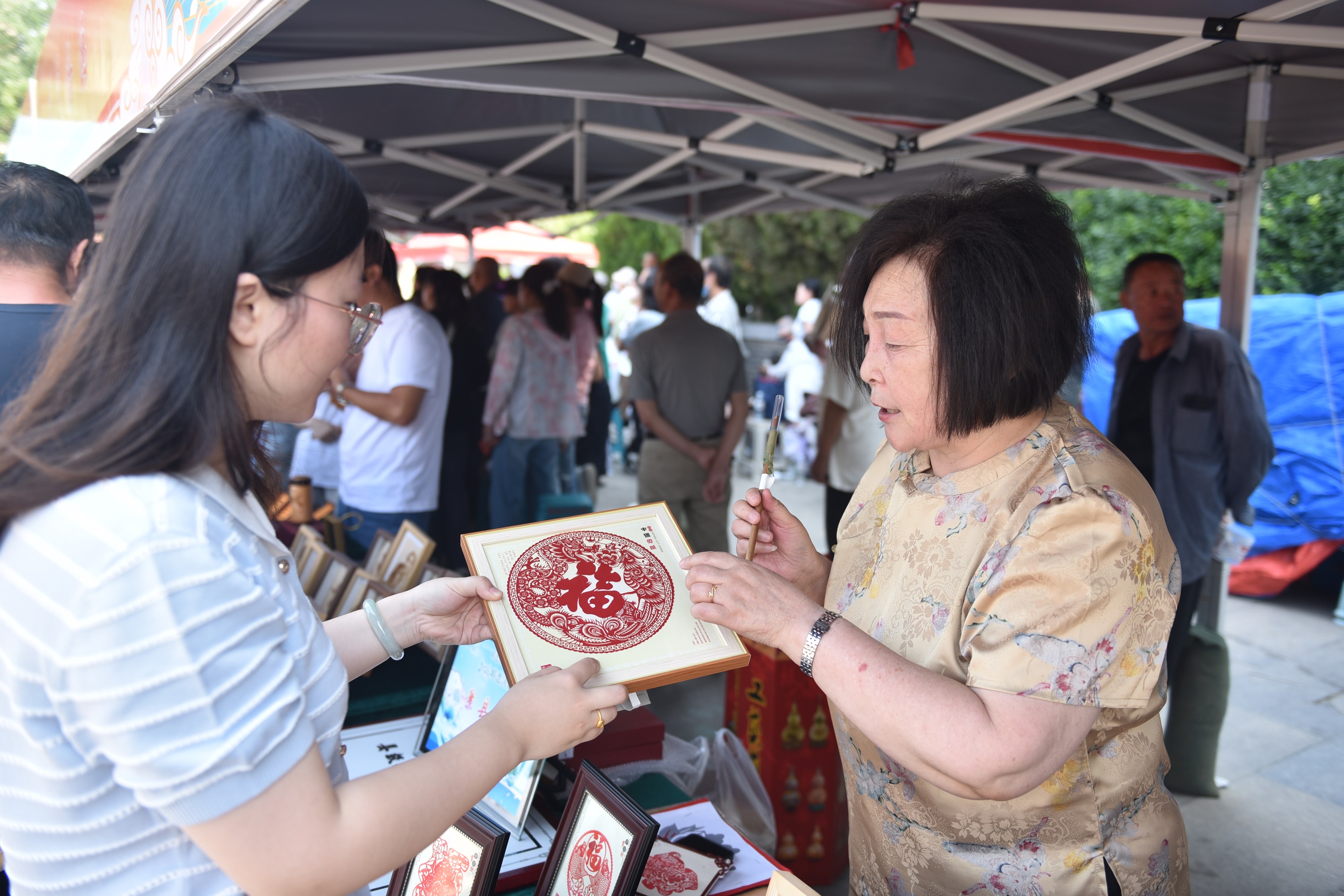 县级非遗项目景县剪纸传承人在为游客介绍剪纸技艺。高雷摄