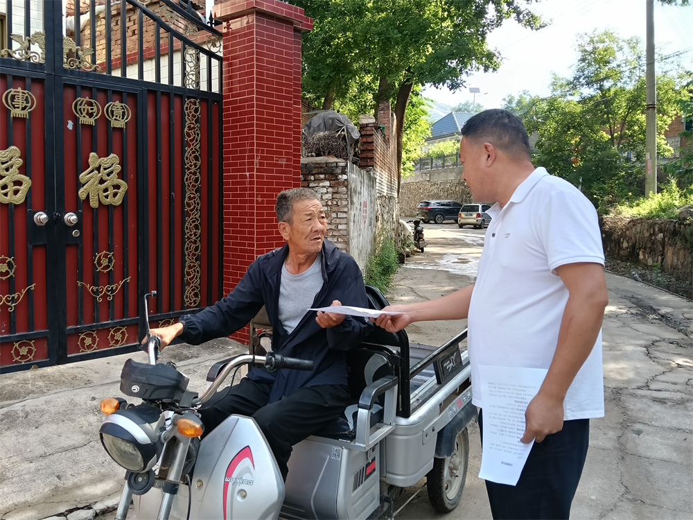 白合镇上赤城村工作人员正在发放明白纸。唐县县委宣传部供图