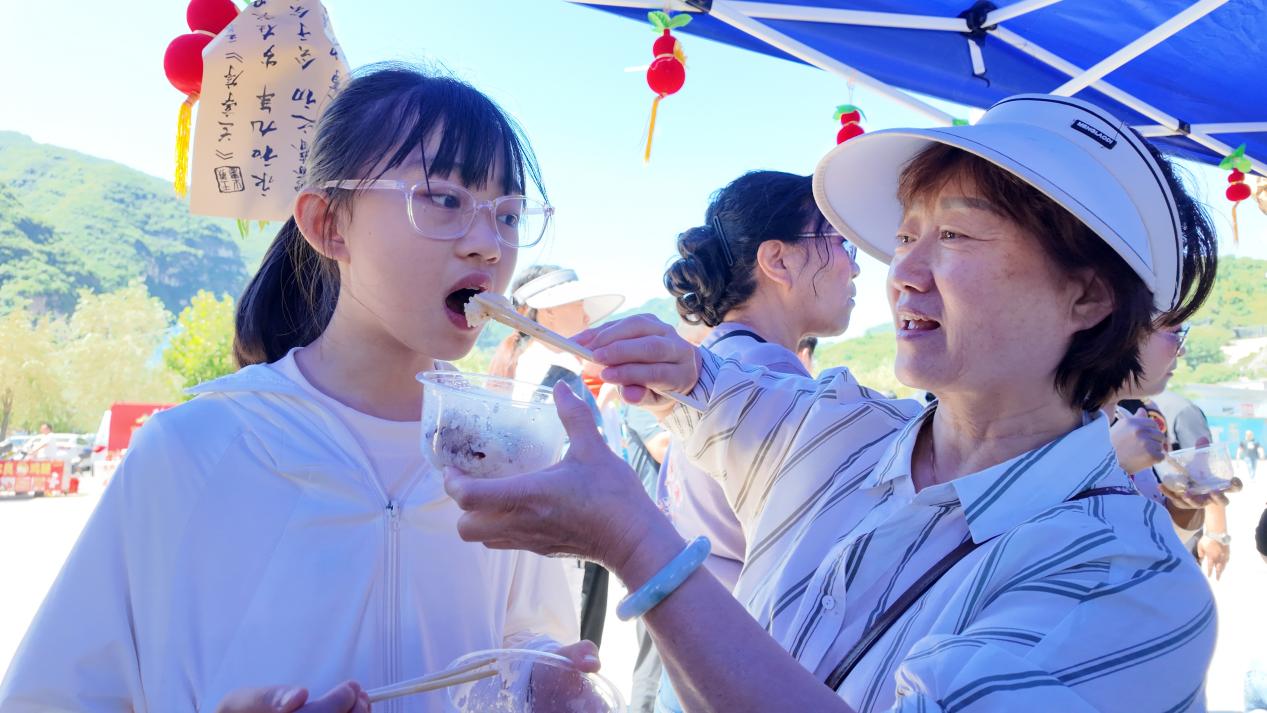 游客正在品尝端午粽子。何可人摄