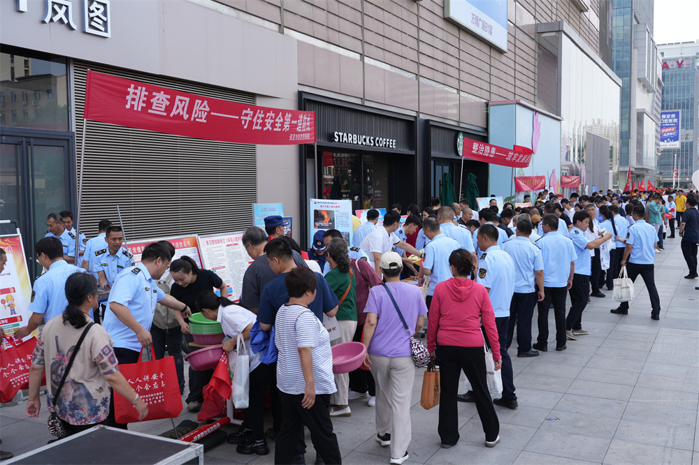 活动现场,群众领取兑换宣传册、环保袋等纪念品。王杜超摄