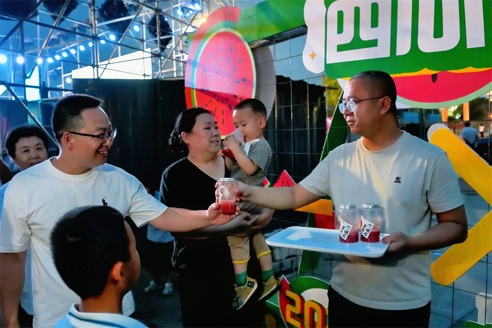 6月18日，在马庄西瓜节上，市民正在品尝鲜榨西瓜汁。张泽慧摄