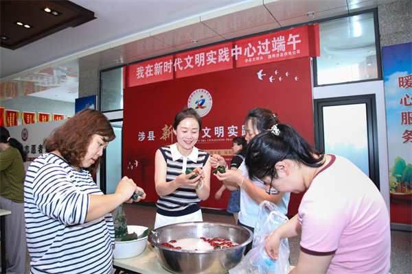 在涉县新时代文明实践中心,一线工作者们聚在一起包粽子。江浩南摄