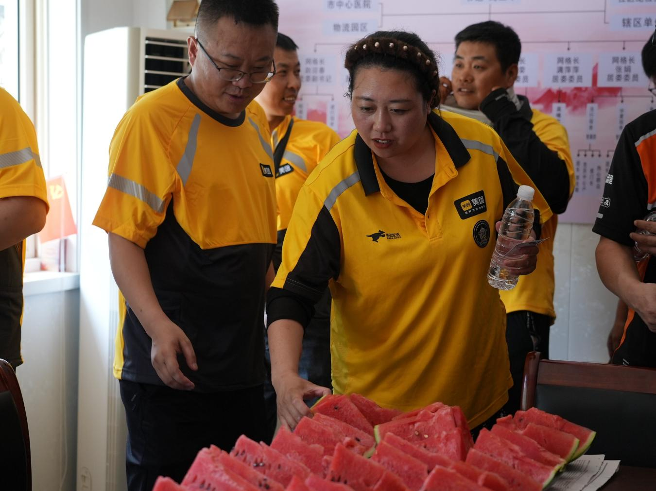 志愿者为外卖骑手送上冰镇西瓜。李虹熹摄