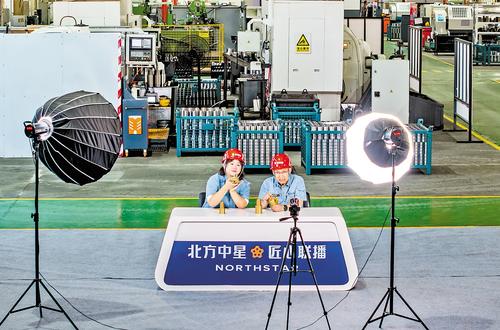 6月23日，张家口市北方中星集团共享工厂生产车间，副总经理刘满学（右）和员工一起直播推介产品。本报记者 赵 杰摄
