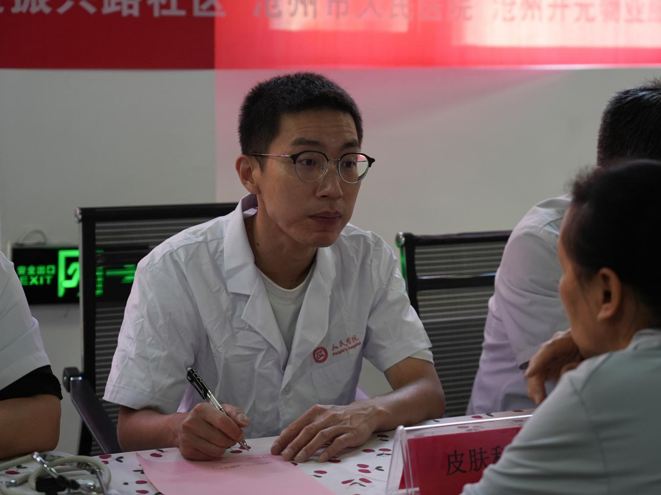 医护人员耐心询问居民的身体状况。李虹熹摄