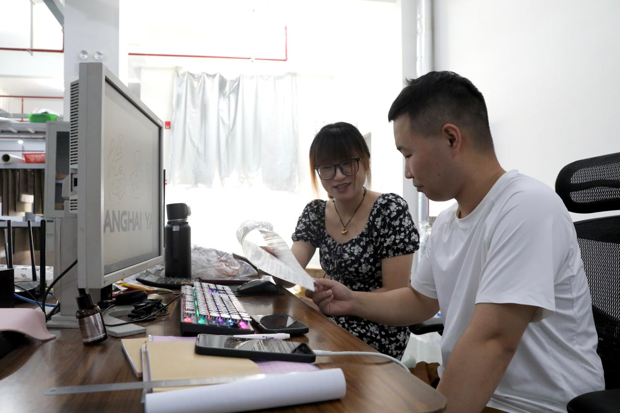 工作人员讨论印花设计方案。刘巨雷摄
