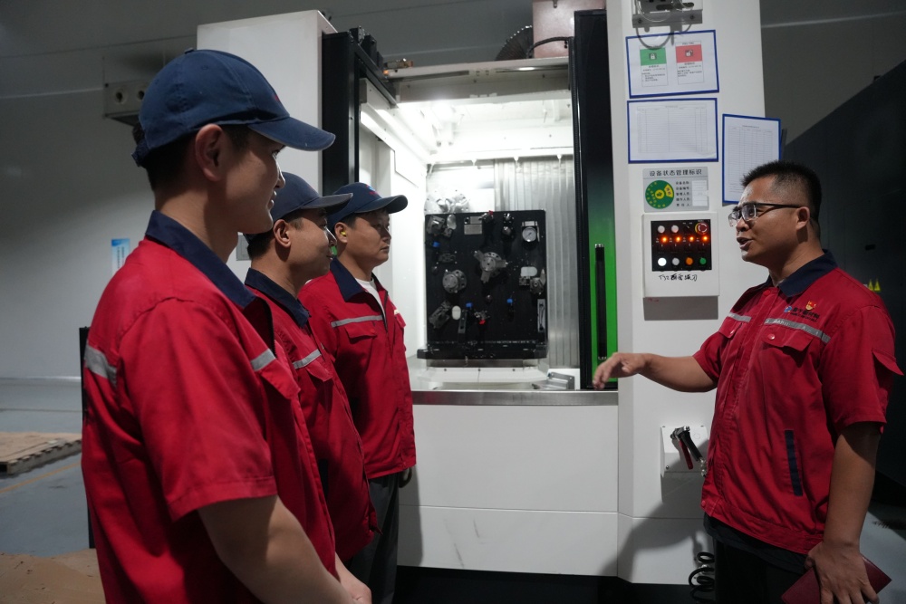 6月29日，河北量子數字新材料有限公司車間內，黨員技術骨干為新員工講解智能設備操作。張冬茹攝