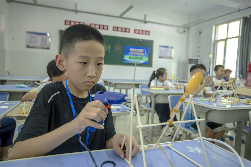 7月4日，河北省邯鄲市第五中學，參賽學生正在組裝拋石掠地項目器材。聶長青攝