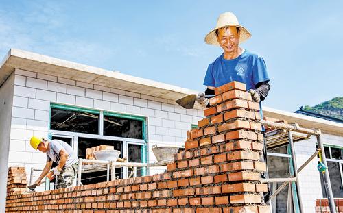 7月7日，承德市兴隆县朱家沟易址安置点，工人在砌院墙。 本报记者 赵 杰摄