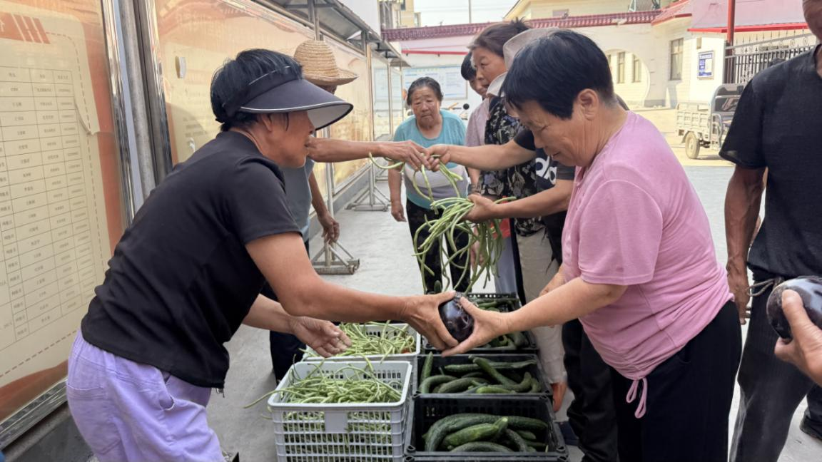 武安市石洞鄉什裡店村老人在領取蔬菜。金簫攝