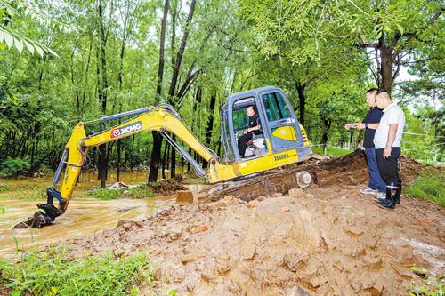 7月12日，遷西縣舊城鄉龍王廟村，村“兩委”干部正在指揮挖掘機對排水點清淤。本報記者 郭寶強攝