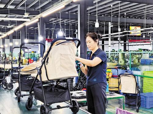 7月16日,在河北绿源童车有限公司生产车间,工人正在拼装童车。本报见习记者 冯依凡摄