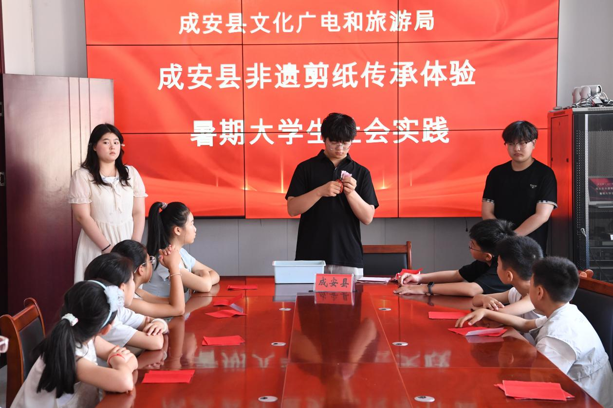 返乡大学生手把手教学剪纸。许朋钰摄