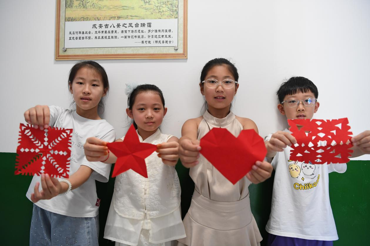 返乡大学生手把手教学剪纸。许朋钰摄