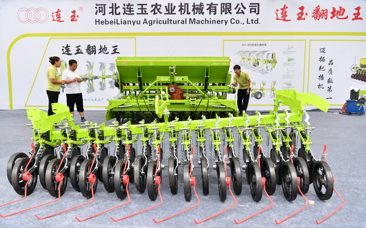 7月17日，工作人员（右一）在阁辛庄村农机具推介活动中向客商推介农机产品。苑立伟摄