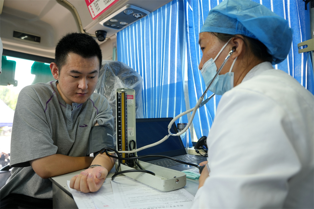 7月27日，河北省隆堯縣醫院獻血車上，獻血人員正在測量血壓。張冬茹攝
