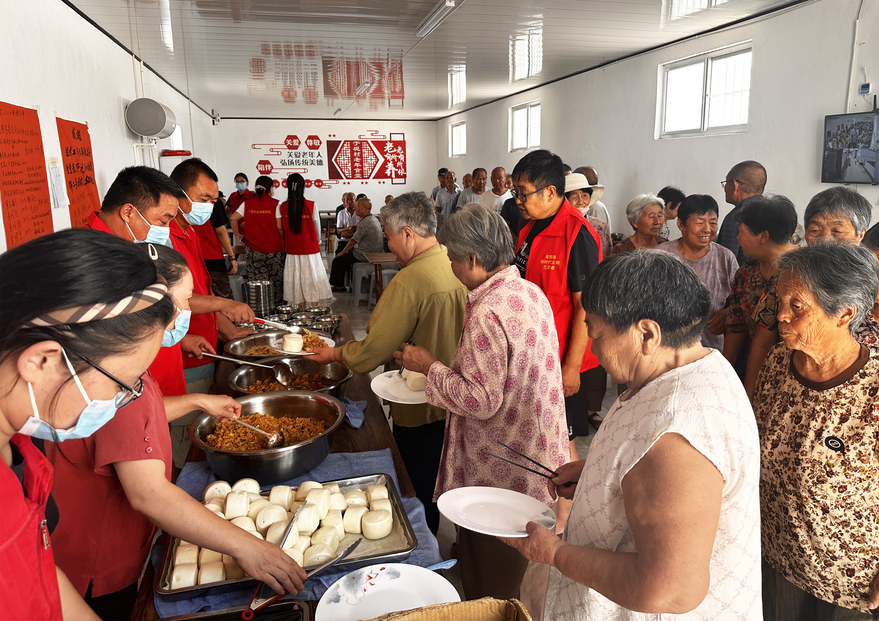 8月5日中午，在於堤村老年食堂，老人們排隊打飯。石艷宣攝