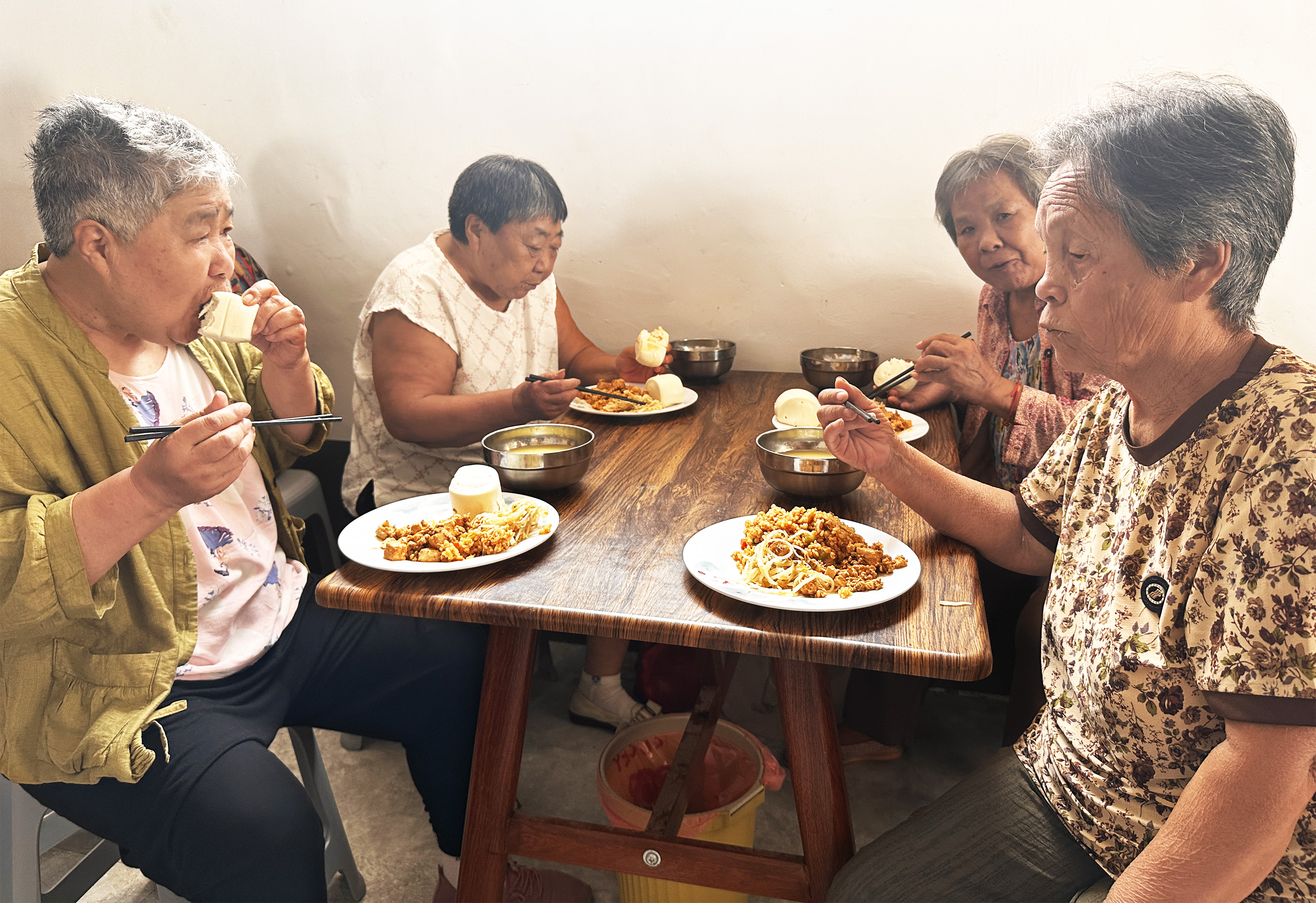 8月5日中午，在於堤村老年食堂，老人們圍在桌前吃午飯。石艷宣攝