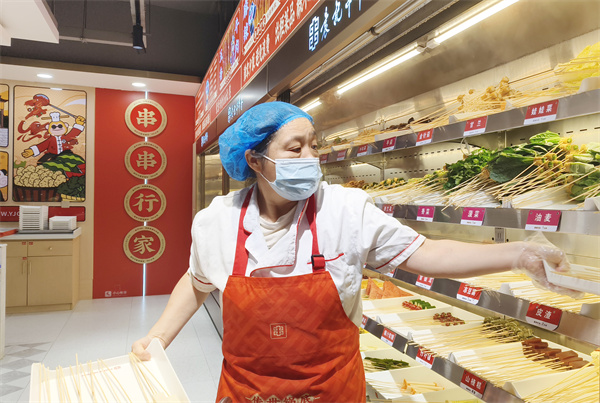 小吃店工作人员规范摆放各类菜品。郝立翠摄