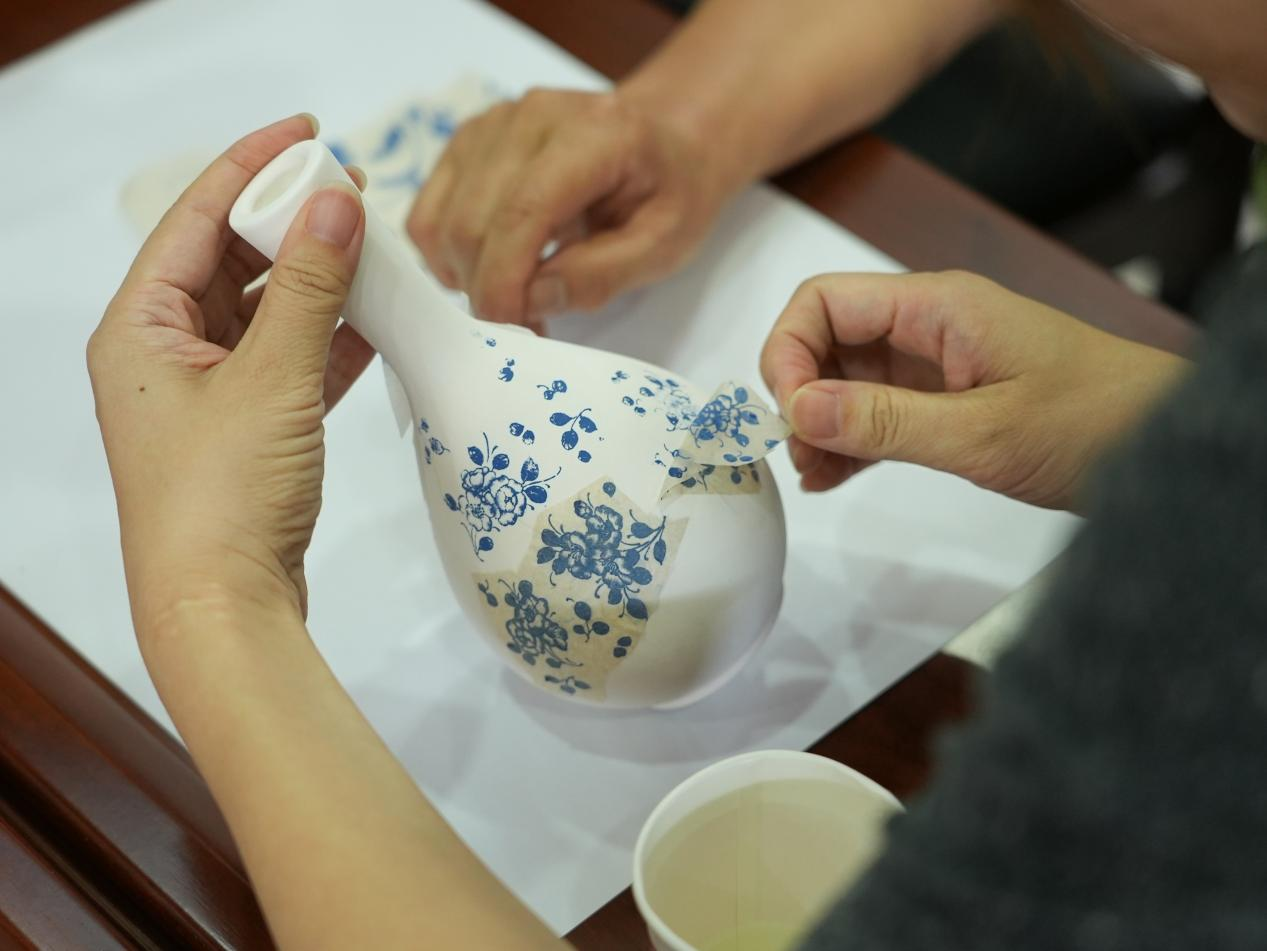 经过贴纸、沾湿、成画等步骤，瓷瓶上晕染出青花纹样。李虹熹摄