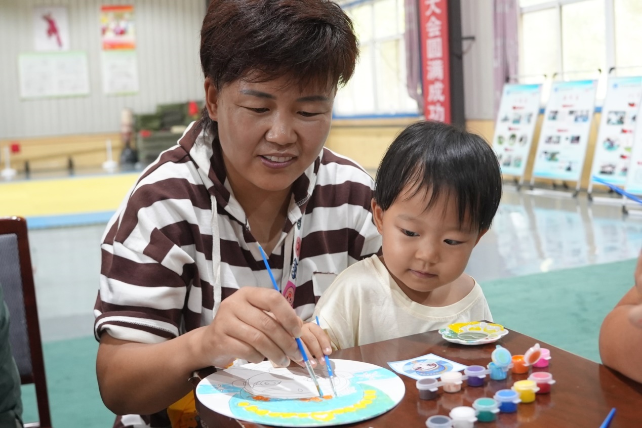 亲子共同绘制手工团扇。徐彩云摄