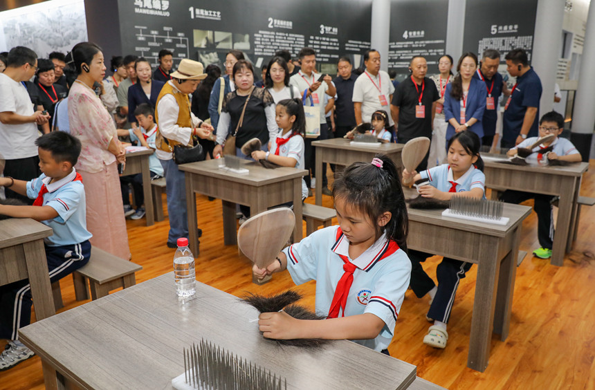 8月20日，在安平县中国丝网展览馆，参加活动人士观看研学学生手工制作传统马尾箩。陈康摄