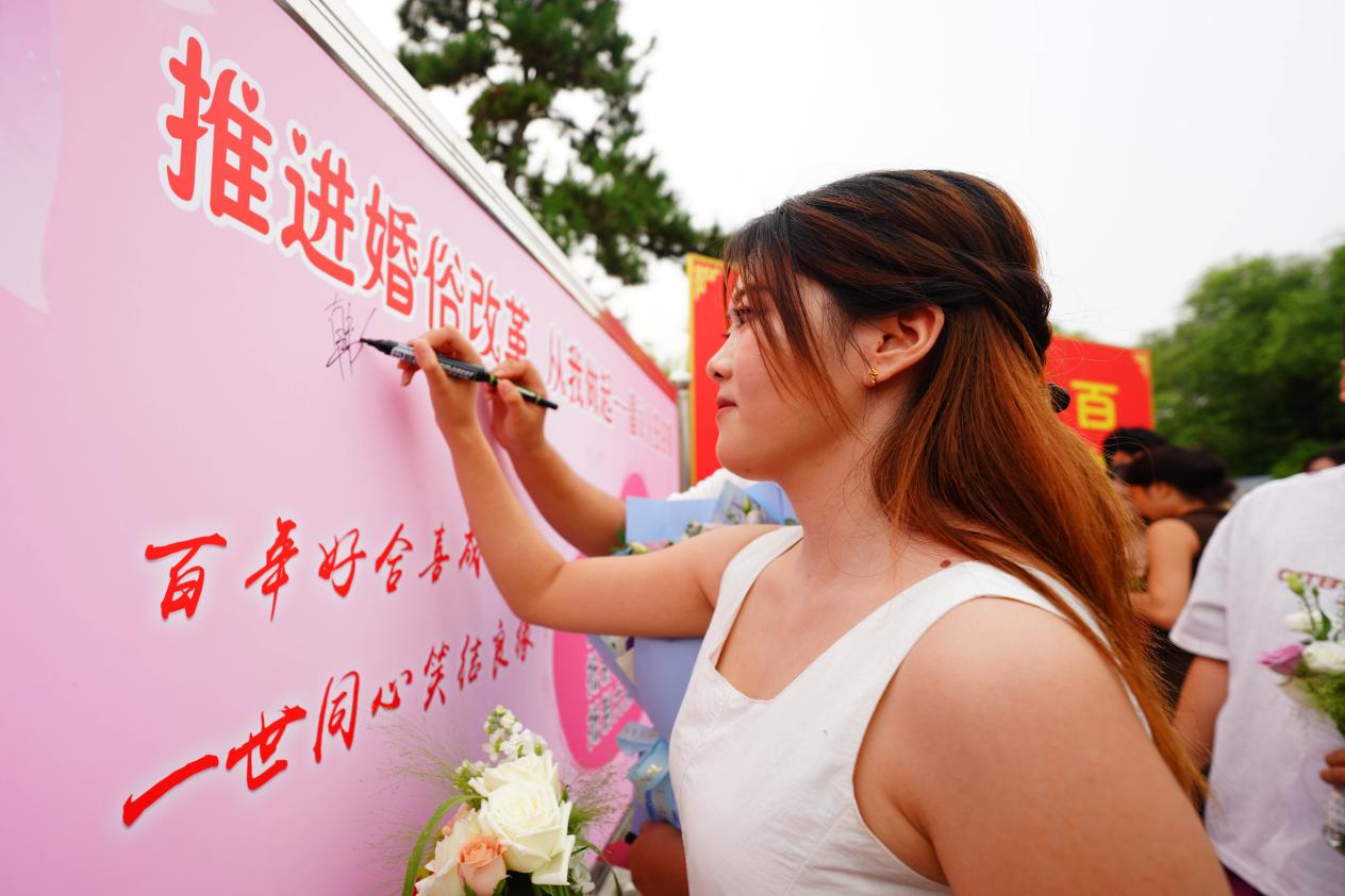8月19日，河北邢台任澤區一對新人在“推進婚俗改革從我做起——倡議人簽名牆”上簽名。陳雷 攝