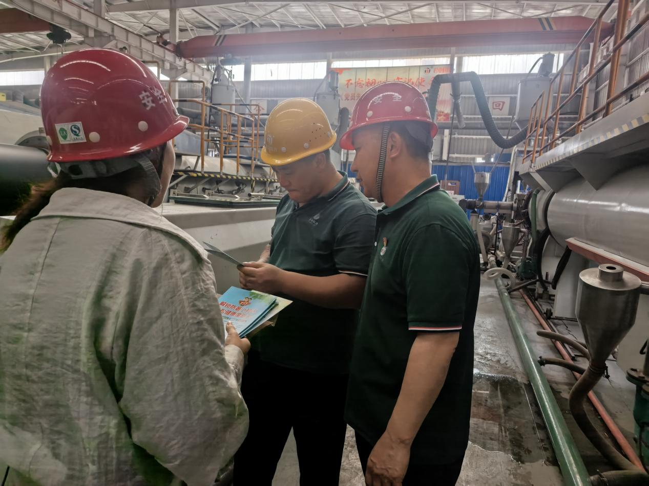 丰南区总工会工作人员为企业工人发放防暑降温知识宣传单。付文艳摄