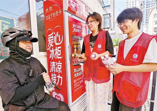 近日,在秦皇岛市海港区团结里社区党群服务中心门前,志愿者为新就业群体送水。秦皇岛市委社会工作部供图