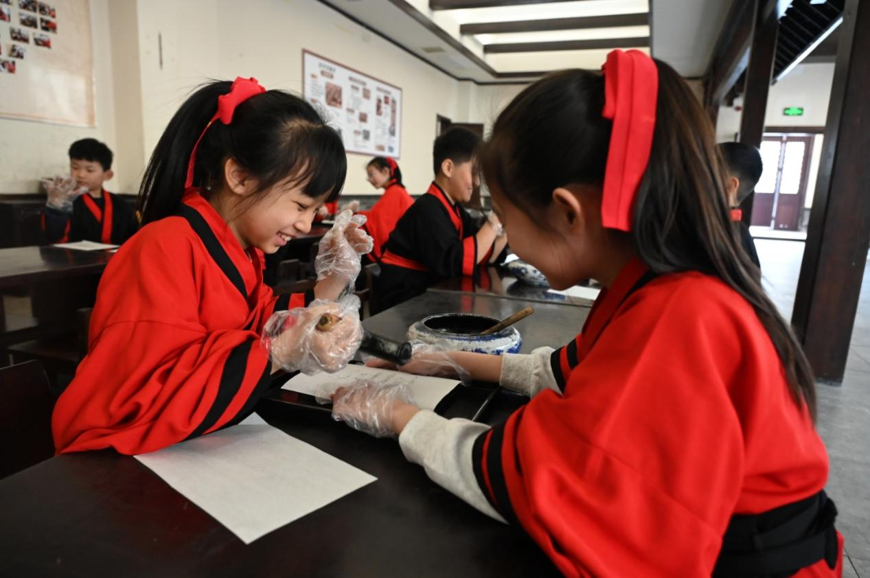 河北衡水湖景区孙敬学堂，研学学生身着汉服体验活字印刷。周津摄。