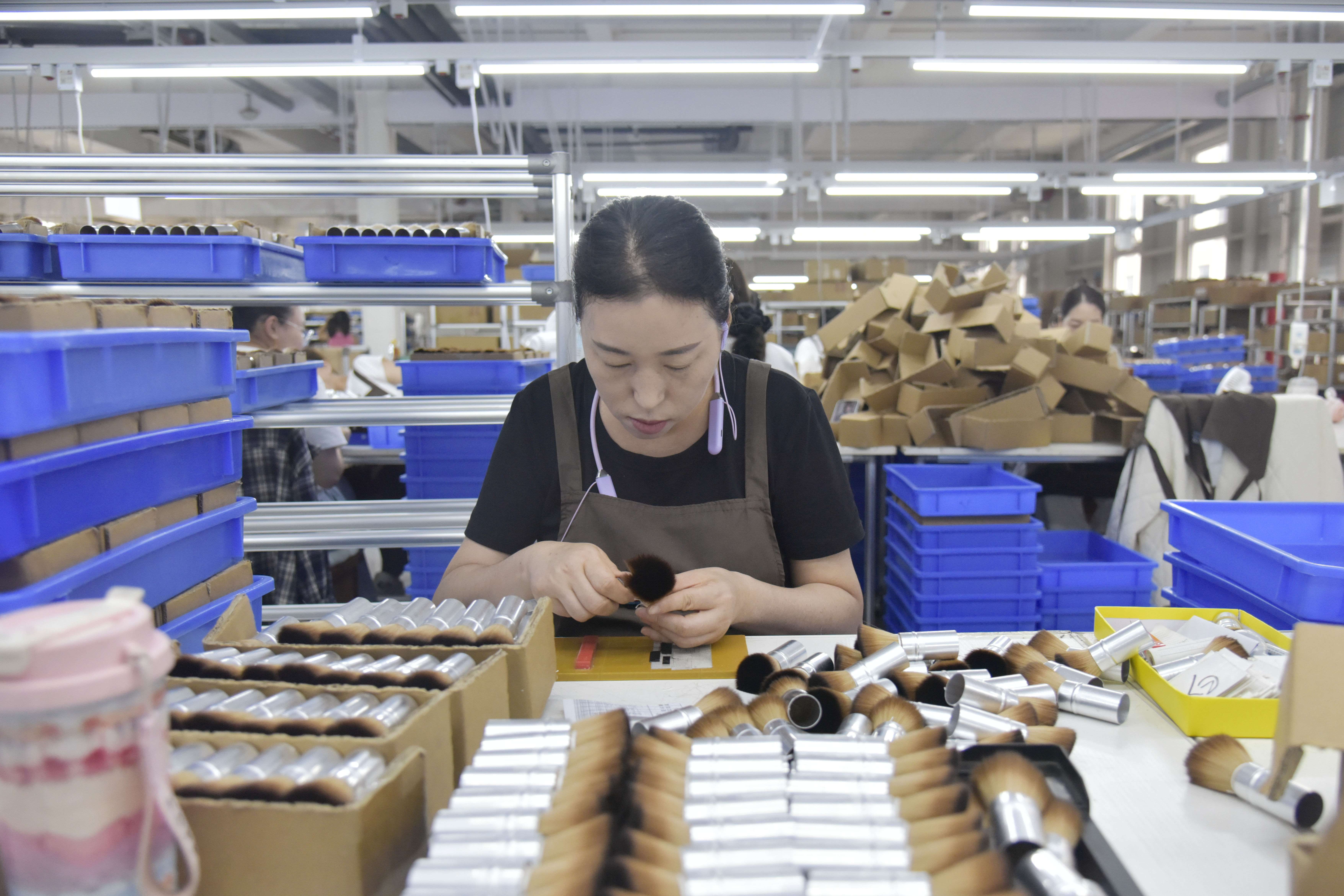滄州市卓爾雅美妝有限公司內，工人對刷毛進行豎管。尹向平攝