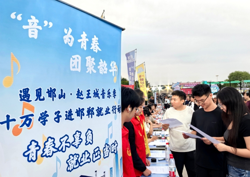 青年游客在“人才夜市”招聘会上了解用人单位信息。王志宏摄