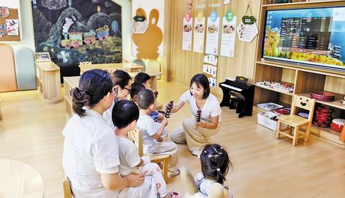 8月25日，在保定市妇幼保健院托育中心，托育老师给孩子们上音乐课。本报记者 赵泽众摄
