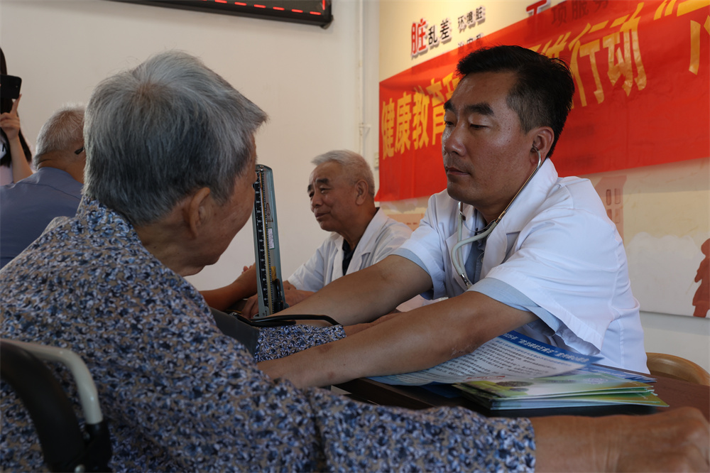医务志愿者为居民进行义诊。 陈征摄