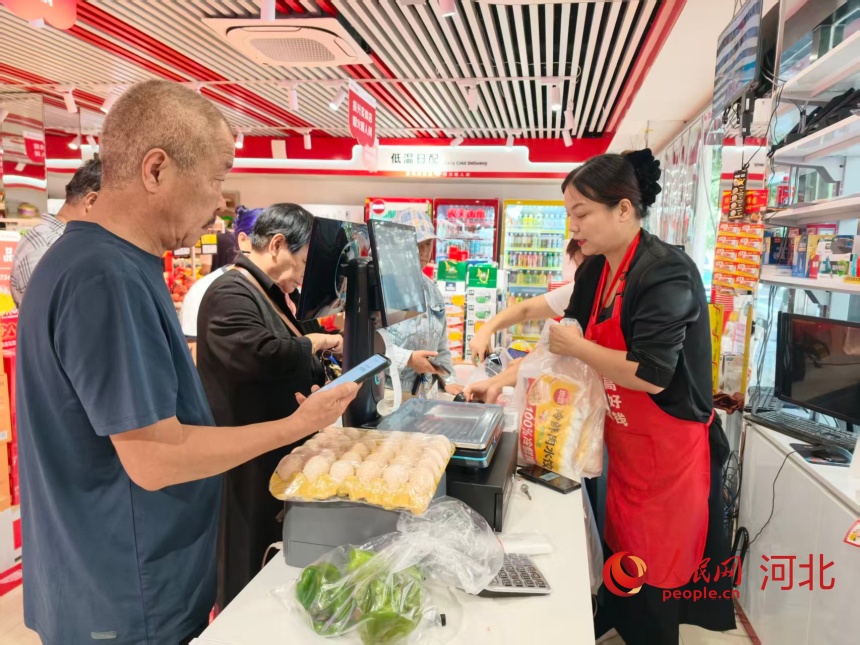 9月12日，同福爆品店小逸鮮品生活超市店主米玉領正在為顧客結賬。人民網記者 朱延生攝