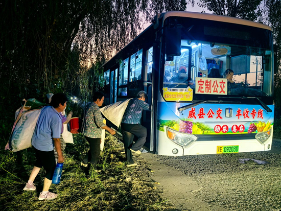 村民们背着刚收的农作物登上返程公交。穆新灵摄
