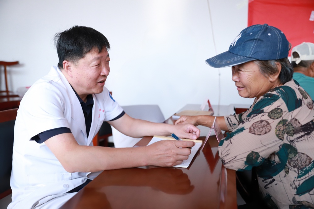 9月18日，医务人员正在为村民提供健康咨询服务。蔡依娜摄