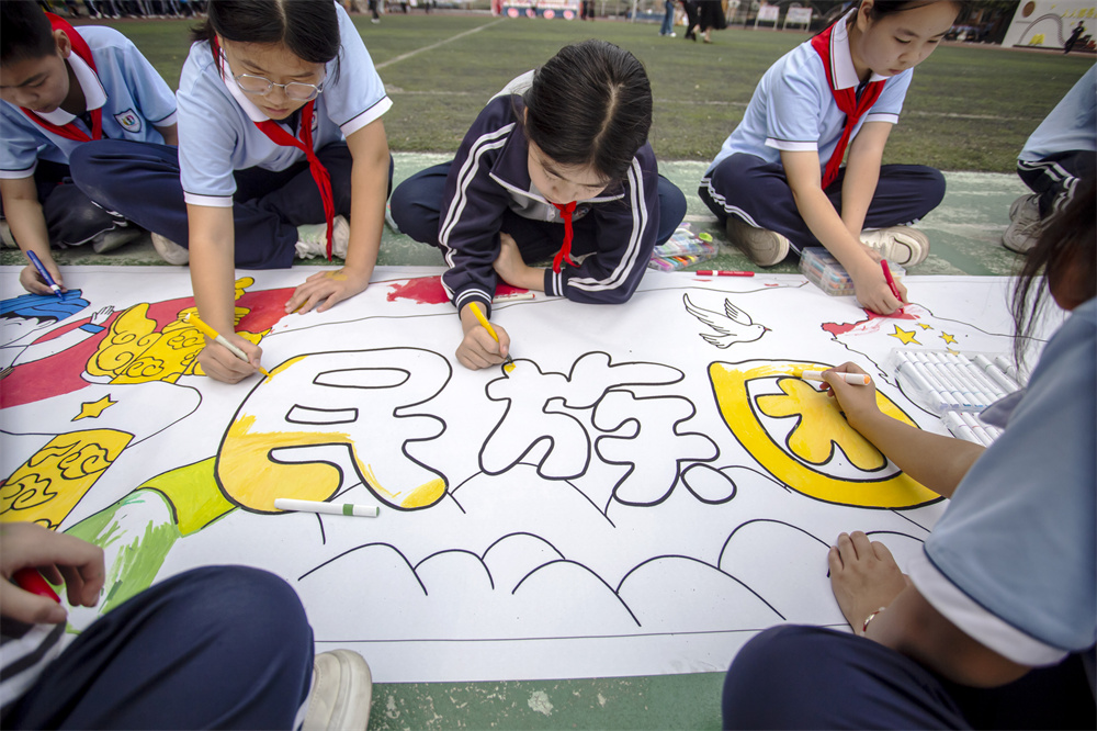 孩子们在描绘民族团结一家亲长画。聂长青摄