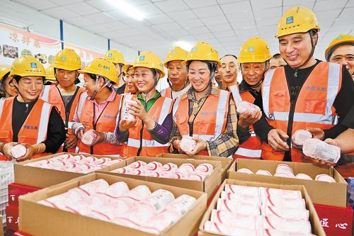 9月25日，在石家庄高鐵片區57號地塊項目生活區，工人們下班后在食堂領月餅相聚過中秋。本報記者 史晟全攝