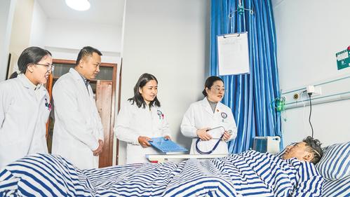 9月25日，河北援藏醫生張花平（左四）和閆立華（左二）到病房巡診。本報記者 李東宇攝